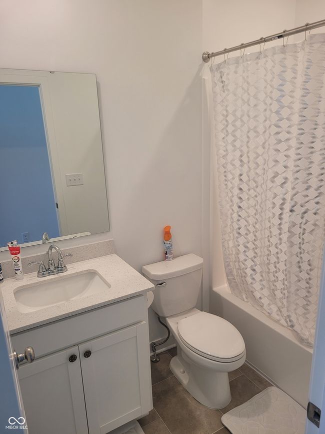 full bath featuring vanity, shower / tub combo, and tile patterned floors | Image 18