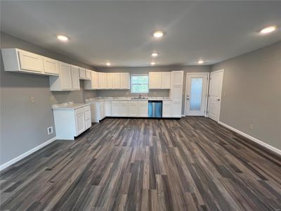 Kitchen with white cabinets, stainless steel dishwasher, sink, and dark hardwood / wood-style floors | Image 3