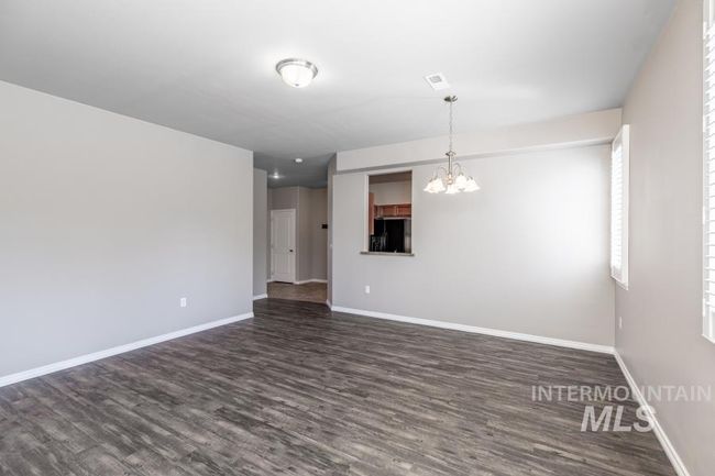 Empty room featuring dark wood-type flooring and a chandelier | Image 11