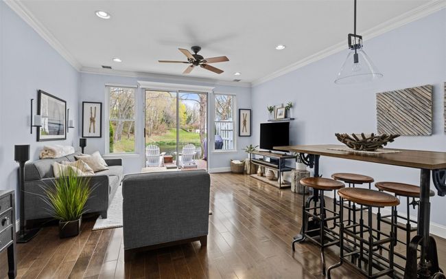 Living room featuring ceiling fan, baseboards, crown molding, and wood finished floors | Image 4