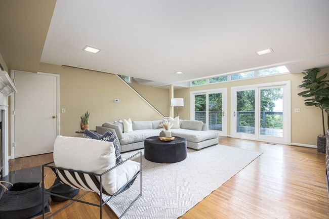 This laid-back living room is thoughtfully designed for both relaxation and connection. It features direct access to a private balcony overlooking rolling hills and the peaceful valley below. | Image 19