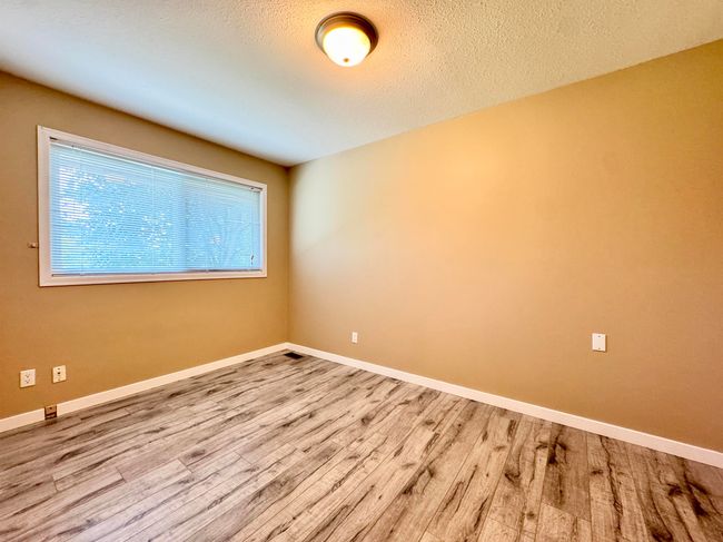 Empty room featuring wood finished floors and a textured ceiling | Image 8