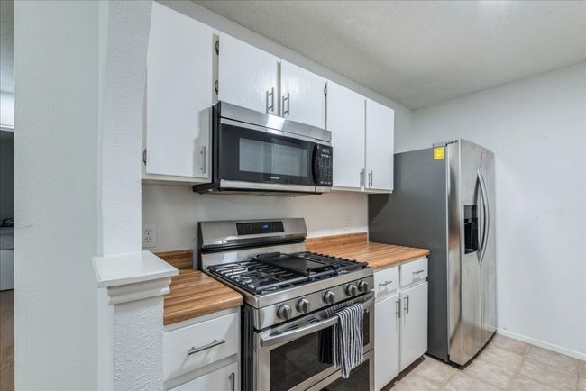 Kitchen featuring white cabinets and appliances with stainless steel finishes | Image 10