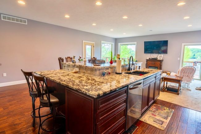 Kitchen with visible vents, dishwasher, a sink, recessed lighting, and dark wood-type flooring | Image 11