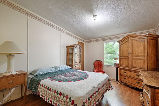 Bedroom featuring wood finished floors and a textured ceiling | Image 18