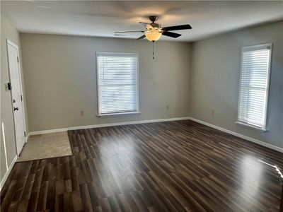 Empty room featuring dark hardwood / wood-style floors, ceiling fan, and a wealth of natural light | Image 3