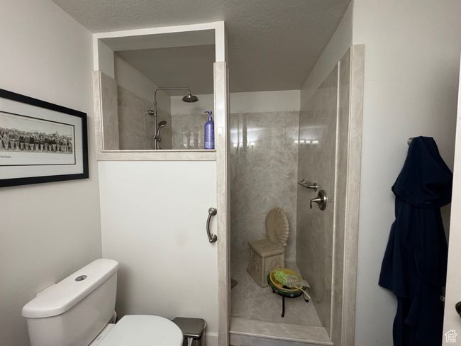 Bathroom featuring toilet and tiled shower | Image 12