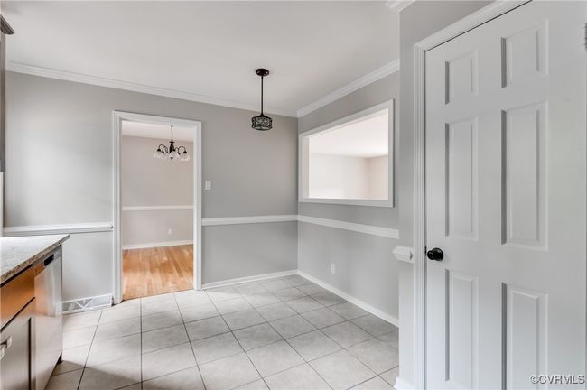 Unfurnished dining area featuring a chandelier, light tile patterned flooring, and crown molding | Image 10