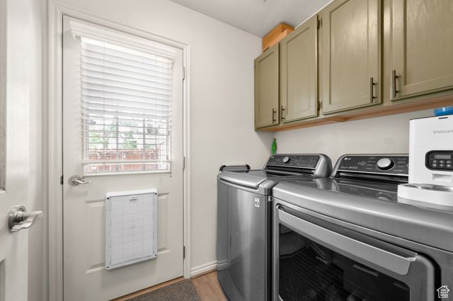 Laundry area with independent washer and dryer, cabinet space, and light wood-type flooring | Image 21