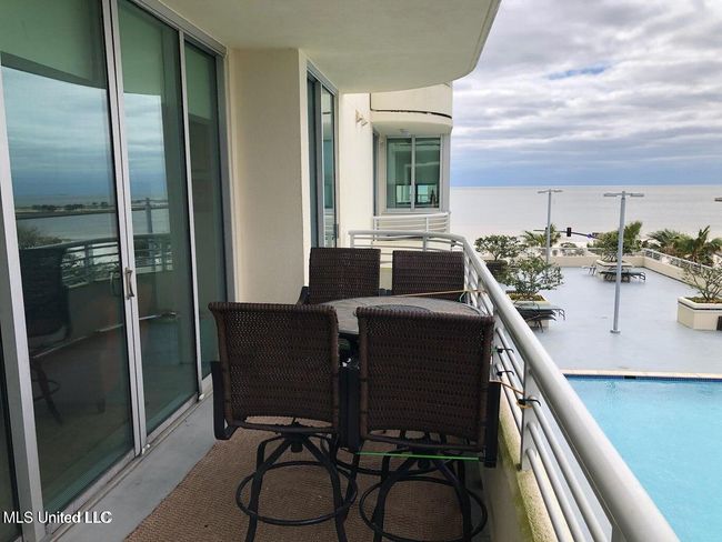 balcony view outside with pool and gulf | Image 15