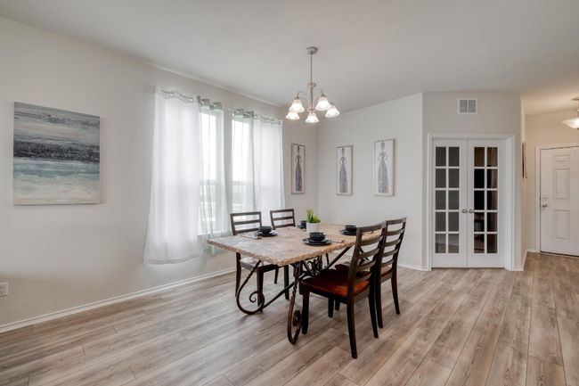 Dining area featuring baseboards, visible vents, light wood-style floors, and an inviting chandelier | Image 8