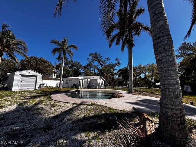 View of swimming pool with a fenced in pool, fence, a storage shed, an outdoor structure, and a patio area | Image 17