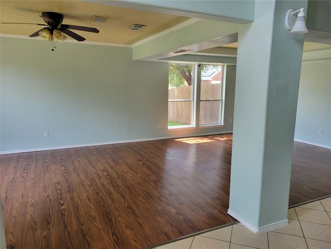 Spare room with crown molding, a ceiling fan, and wood finished floors | Image 9
