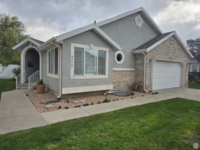 View of front facade with a front lawn and a garage | Image 1