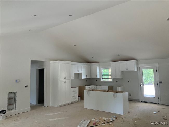 Kitchen with a center island, white cabinetry, and lofted ceiling | Image 25