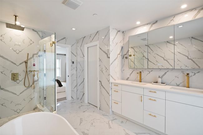 Bathroom with a marble finish shower, a sink, visible vents, recessed lighting | Image 21
