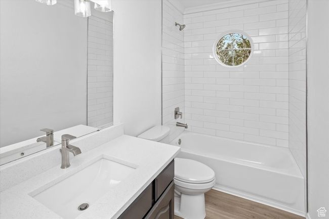 Full bath featuring shower / bath combination, wood finished floors, toilet, and vanity | Image 24