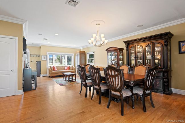 Dining space with light wood-style floors, a chandelier, ornamental molding, and recessed lighting | Image 4