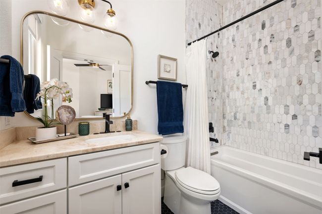 Bathroom with vanity, shower / bath combo with shower curtain, toilet, and ceiling fan | Image 20