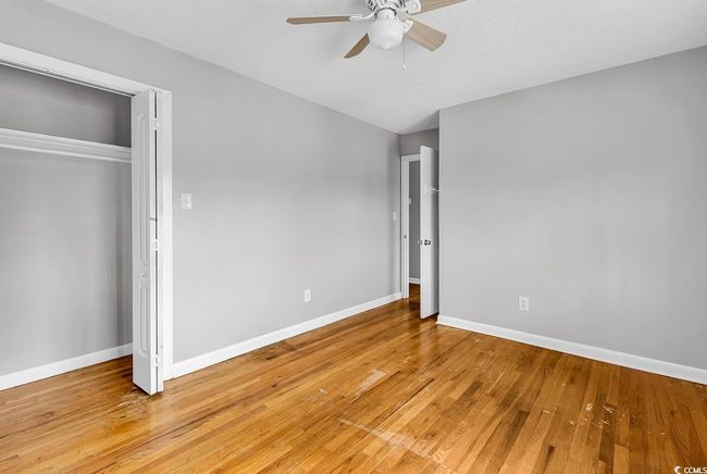 Unfurnished bedroom with light wood-style floors, ceiling fan, and a closet | Image 25