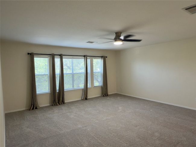 Carpeted empty room with a ceiling fan and baseboards | Image 19