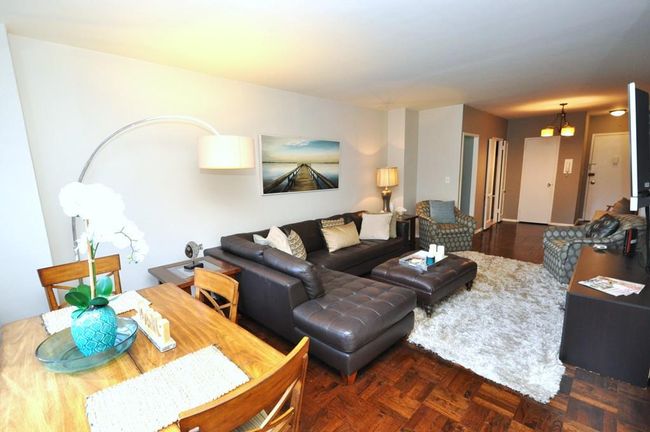 The living room can accommodate a dining and entertainment area and overlooks the North courtyard. The room has parquet floors that extend into the dining foyer. | Image 5