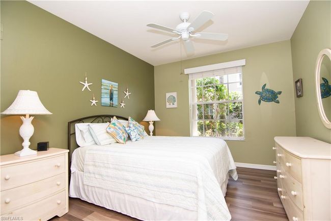 Large guest bedroom with double closet features LVP flooring. | Image 25