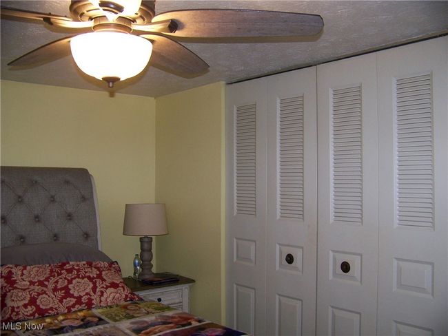 Bedroom featuring a textured ceiling and ceiling fan | Image 8