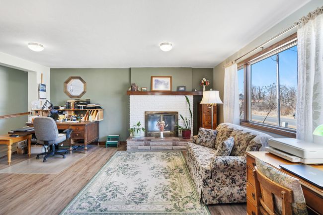 The living room features an inviting, decorative fireplace | Image 6