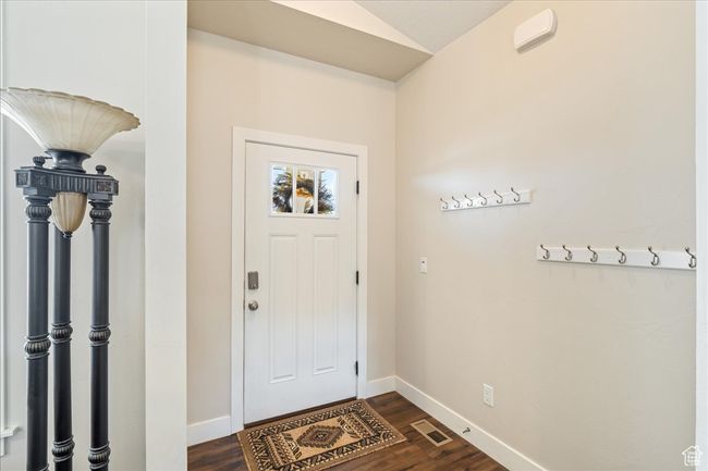 Foyer with lofted ceiling, baseboards, visible vents, and dark wood-style floors | Image 7