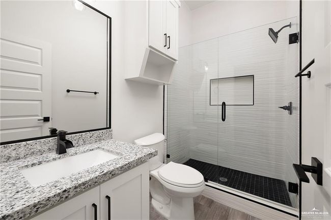 Bathroom featuring a shower stall, vanity, and wood finished floors | Image 7