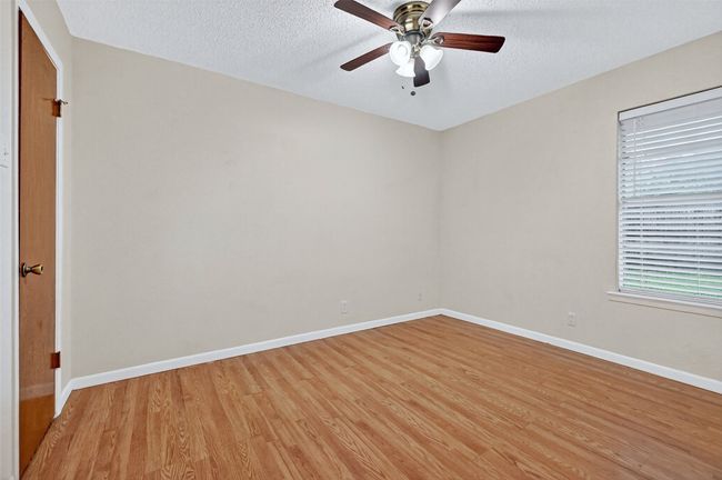 Spare room featuring light wood-type flooring, ceiling fan, and a textured ceiling | Image 16
