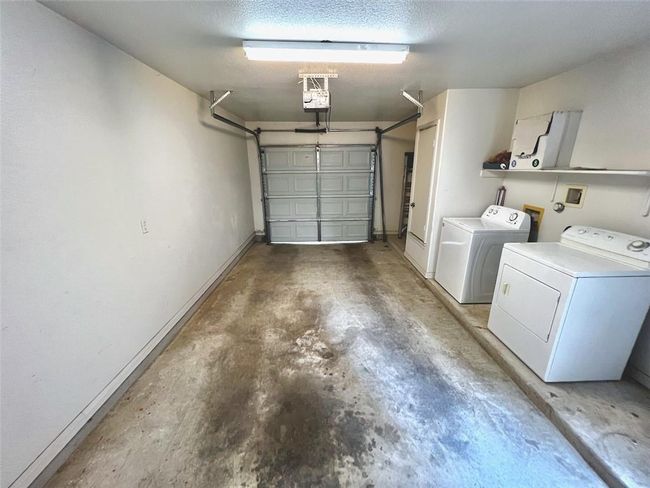Garage with separate washer and dryer and a garage door opener | Image 13