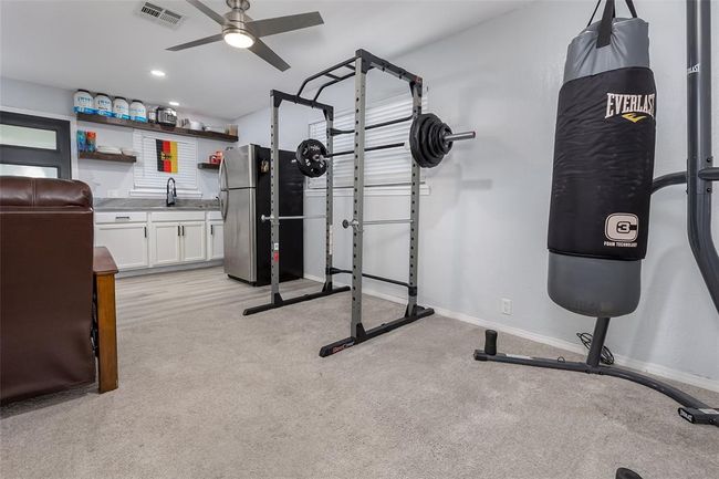 Workout area featuring ceiling fan, light colored carpet, and sink | Image 12