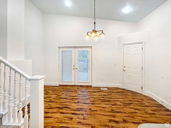 Foyer with baseboards, french doors, wood finished floors, and an inviting chandelier | Image 13