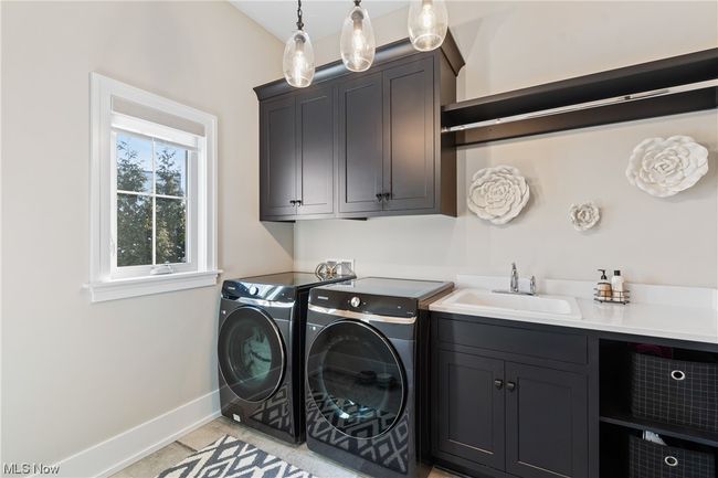 Laundry room with separate washer and dryer, cabinets, sink, and hookup for a washing machine | Image 15