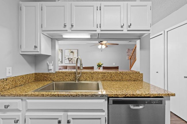 Kitchen with breakfast bar seating and an open pass-through to the living space for easy entertaining. | Image 10