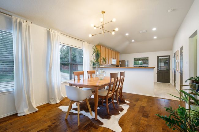 Dining area with a chandelier, light wood finished floors, and lofted ceiling | Image 5