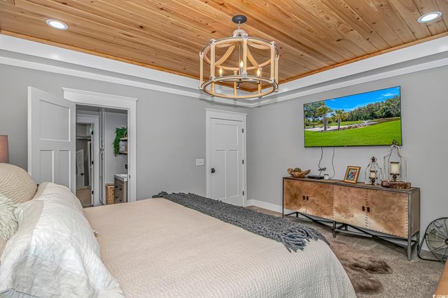 Carpeted bedroom featuring wood ceiling, a chandelier, a raised ceiling, and recessed lighting | Image 18