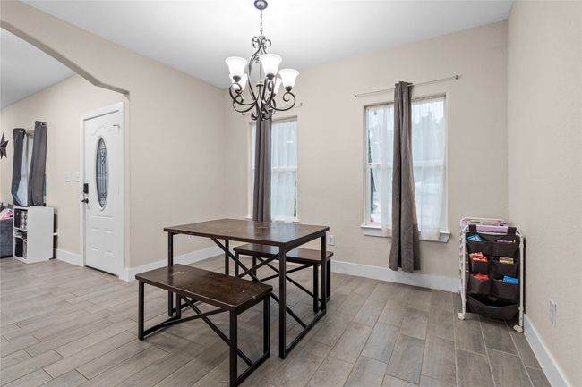 Dining area with light wood finished floors, arched walkways, and a chandelier | Image 18
