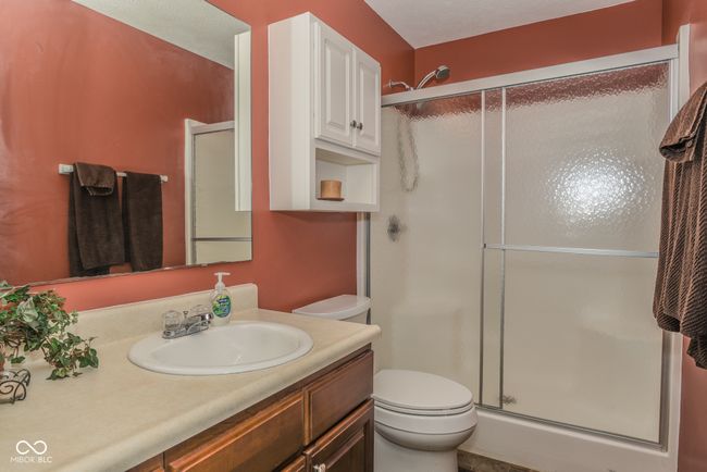 bathroom with toilet, a shower stall, and vanity | Image 14