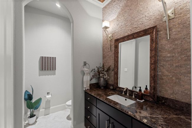An oversized powder bath inside the home offers guests a beautifully appointed space with generous proportions and designer finishes. | Image 24