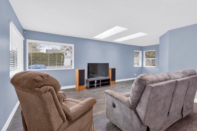 Living area with baseboards, wood finished floors, and a skylight | Image 5