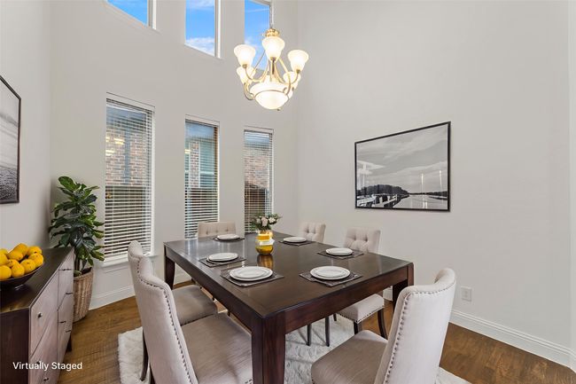 Dining space with a chandelier, dark wood-type flooring, and a towering ceiling | Image 8
