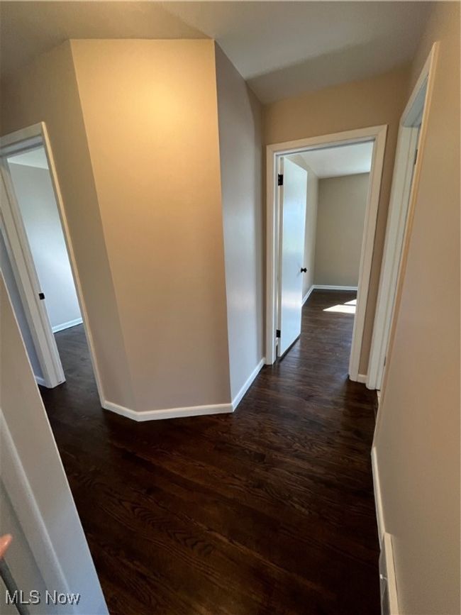Hallway with dark wood-type flooring and hall closet. | Image 20