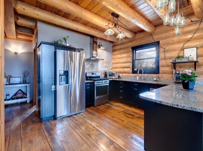 Inviting kitchen features stainless steele appliances, wood floors and granite countertops | Image 15