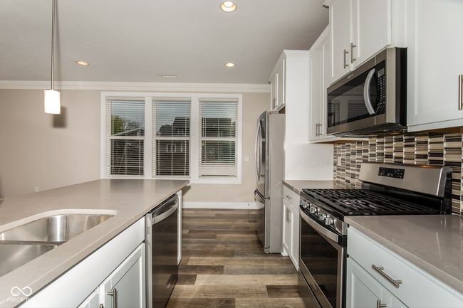 kitchen featuring recessed lighting, dark wood finished floors, appliances with stainless steel finishes, and white cabinetry | Image 14