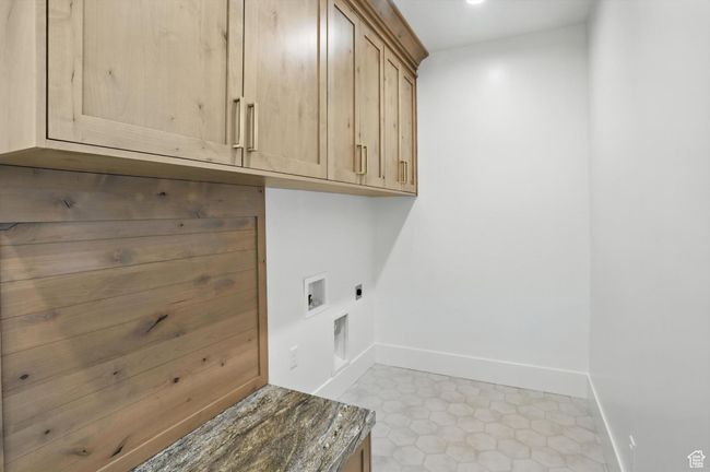 Laundry area featuring cabinet space, hookup for an electric dryer, washer hookup, and tile patterned flooring | Image 38