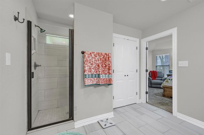 Ensuite bathroom featuring a shower stall, baseboards, and ensuite bath | Image 20