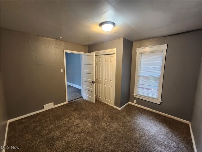 Unfurnished bedroom featuring a closet and dark carpet | Image 10